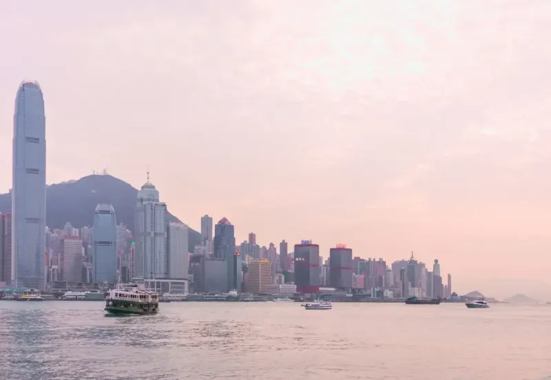 Hong Kong Island skyline and a ferry on Victoria Harbour at sunset: lawyers and advisers in Hong Kong