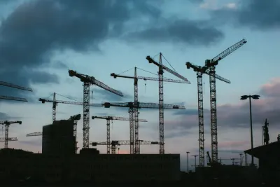 Tower cranes silhouetted against an evening sky over a building site, illustrating the construction adjudication process