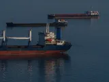 Cargo ships at anchor offshore, illustrating ship arrest and the detention of a vessel as security for a maritime claim