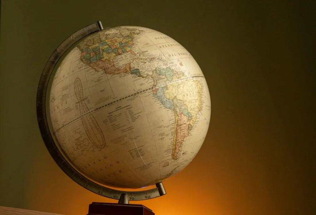 Antique globe on a stand in warm light, symbolising choice of law when you make an international will
