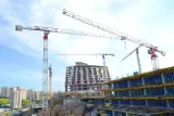 Tower cranes over a high-rise building under construction, illustrating how to choose a construction lawyer