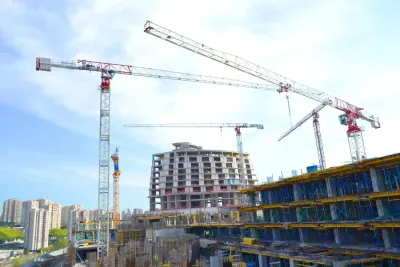 Tower cranes over a high-rise building under construction, illustrating how to choose a construction lawyer