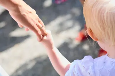A parent holding a young child's hand, illustrating the Court of Appeal ruling on child maintenance top up orders