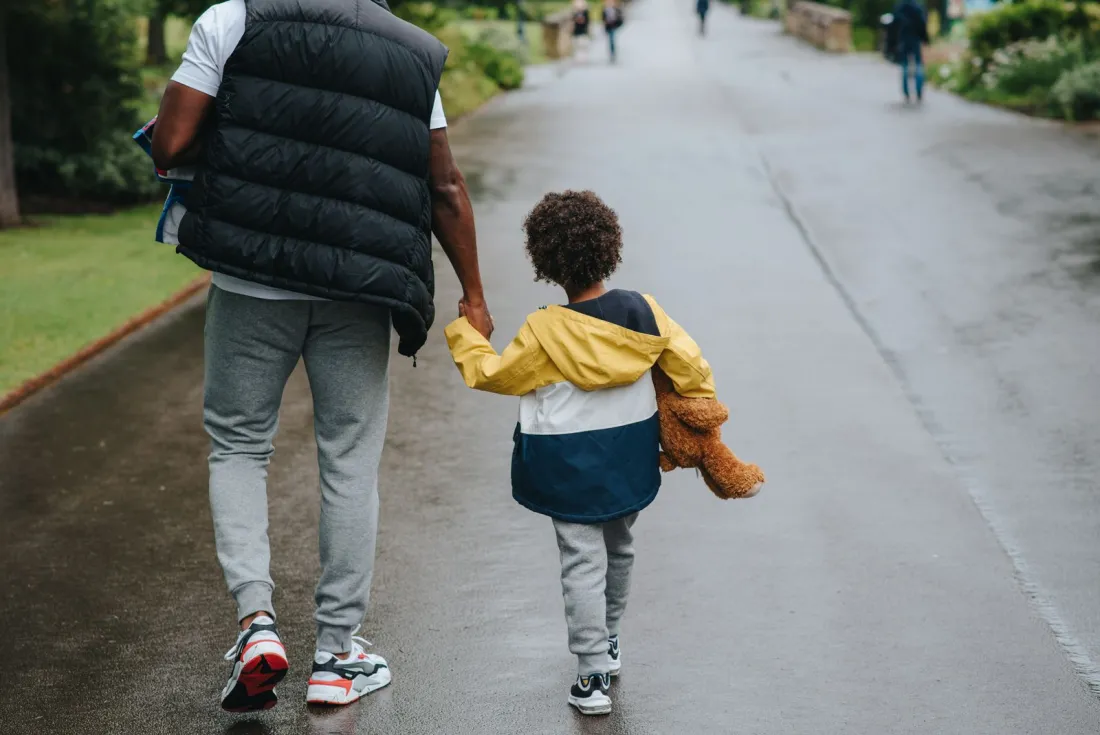 Parent and child walking hand in hand along a path, illustrating the family impact of the Court of Appeal ruling on top up maintenance
