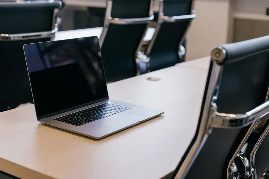 Laptop on an empty boardroom table, where directors weigh claims made vs occurrence when renewing D&O and professional indemnity cover