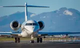 Business jet on a runway with mountains behind, illustrating how to buy a private jet