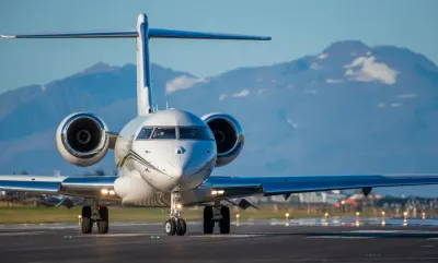 Business jet on a runway with mountains behind, illustrating how to buy a private jet