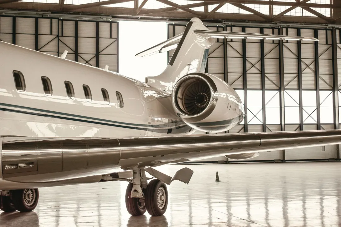 Business jet with its rear engine visible inside a maintenance hangar, the setting for a pre-purchase inspection when you buy a private jet