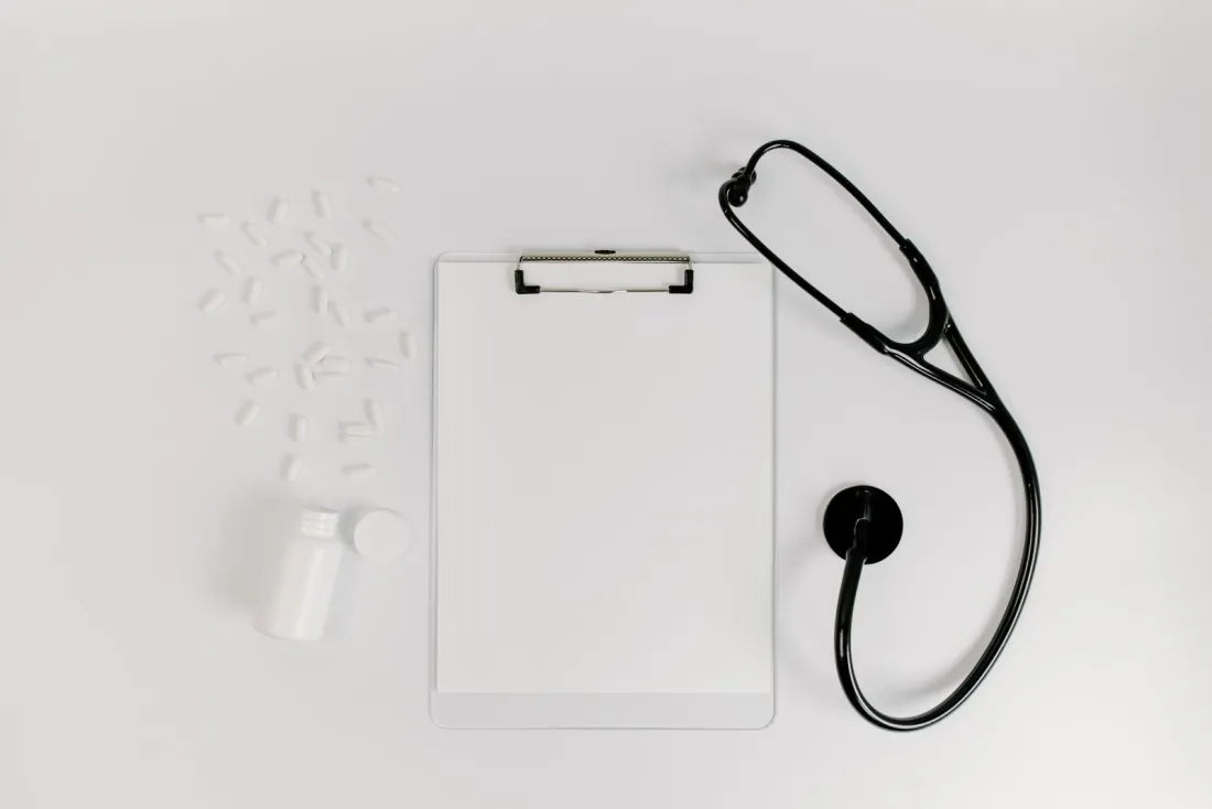 Blank clipboard and stethoscope on a white desk, illustrating the medical records needed to sue a hospital abroad