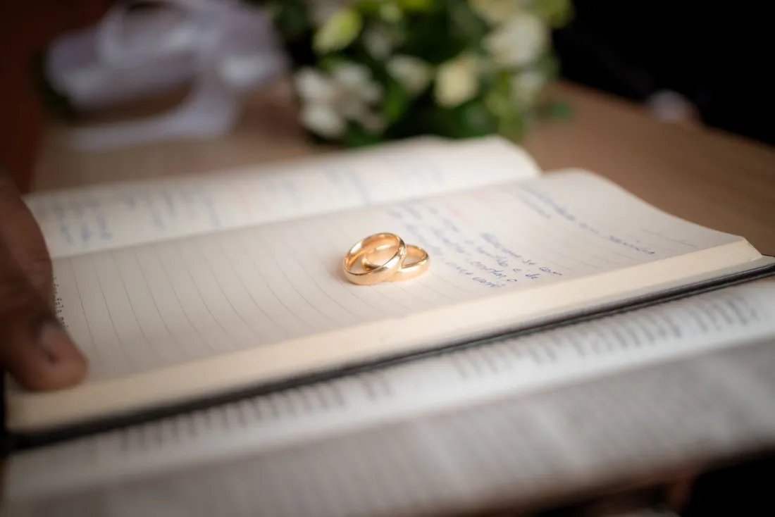 Two wedding rings on an open register, illustrating a prenuptial agreement after marriage in the form of a postnup
