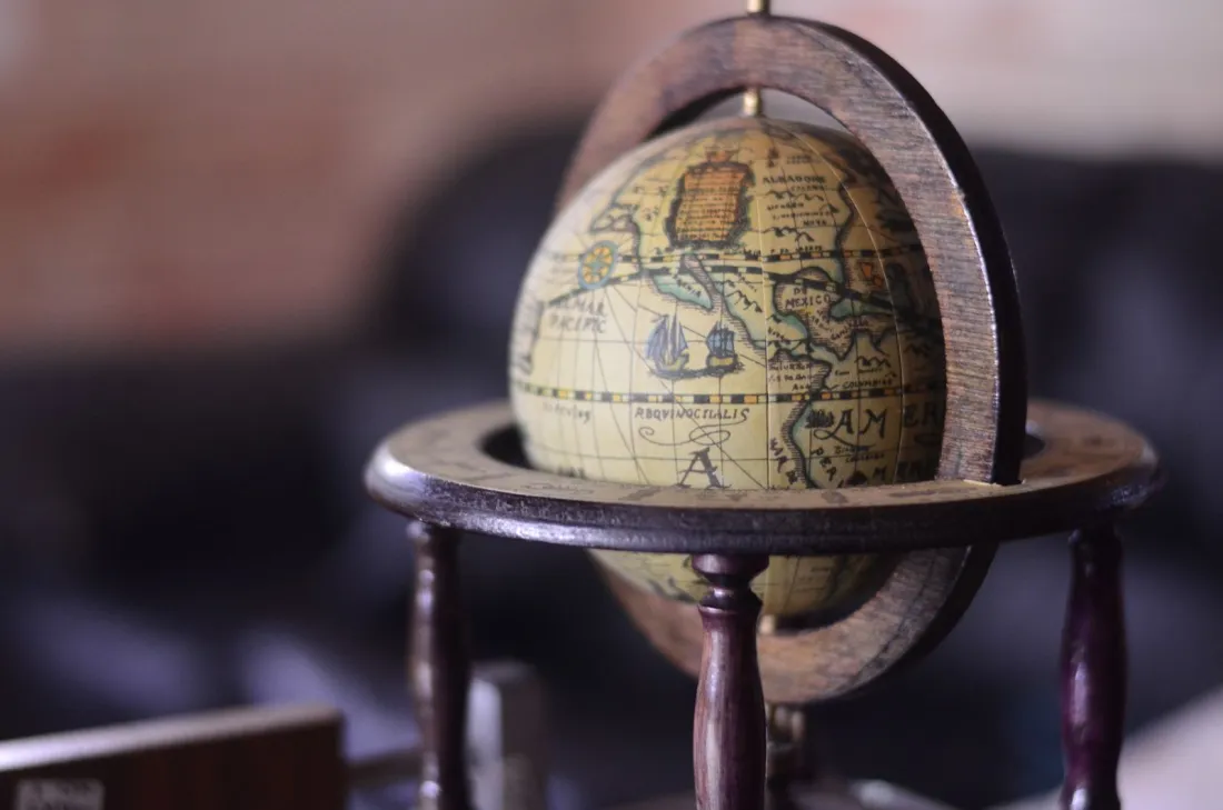 Antique globe on a wooden stand, representing an international prenuptial agreement for couples with assets in several countries