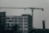 Tower crane over a half-finished apartment block on an overcast day, illustrating what happens if your builder goes bust