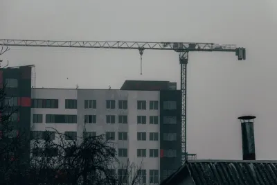 Tower crane over a half-finished apartment block on an overcast day, illustrating what happens if your builder goes bust