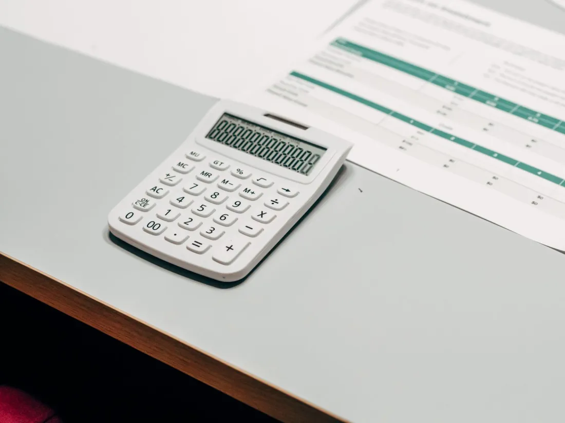 Calculator beside a financial spreadsheet, used to calculate a business interruption insurance claim for lost gross profit