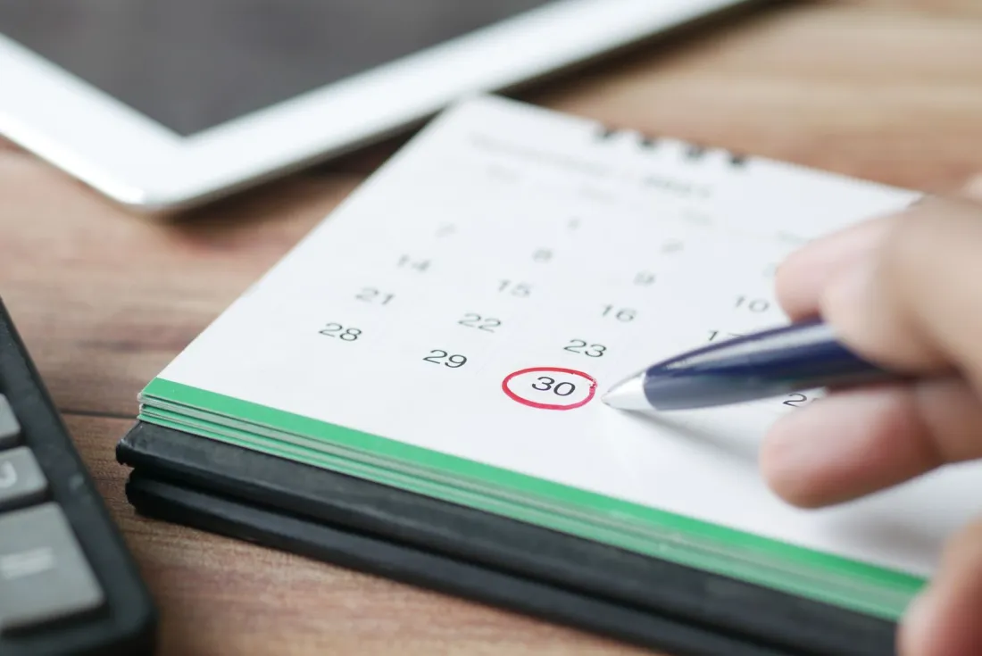Hand circling a date on a desk calendar, marking the Companies House accounts filing deadline