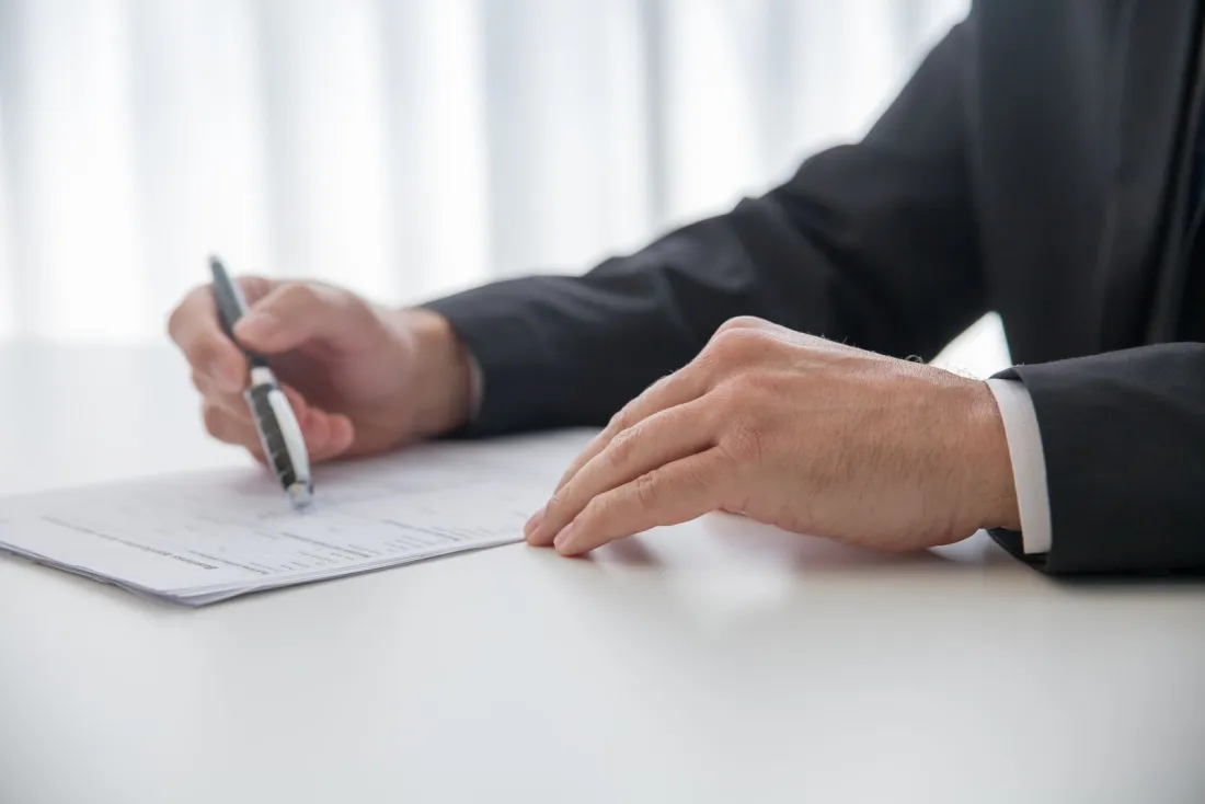 Executive signing an aircraft lease agreement at a desk, illustrating wet lease approval paperwork in the UK and EU