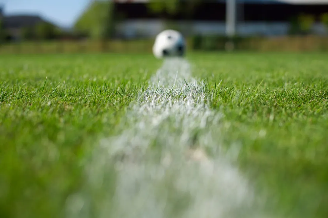 Football resting on a white pitch line, illustrating how image rights for athletes work in English law