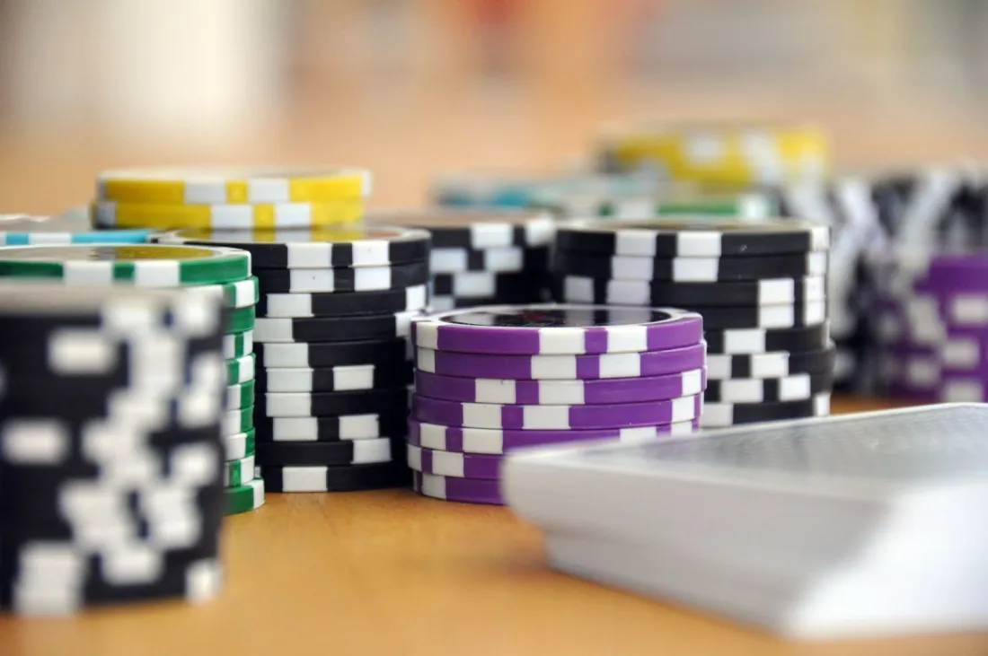 Stacks of poker chips beside a deck of playing cards, real money gaming now restricted by India online gaming law