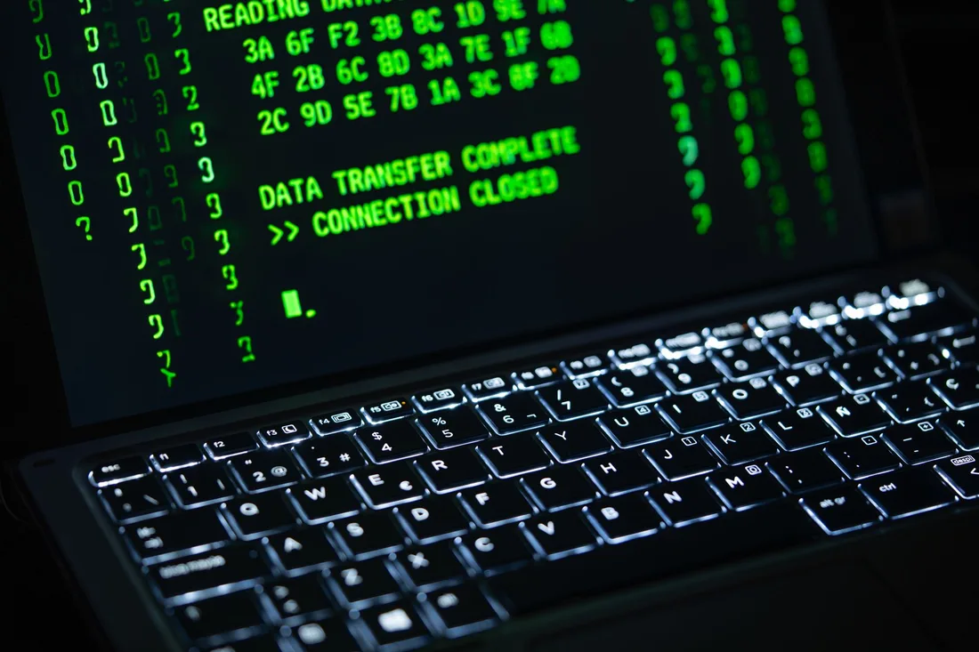 Laptop screen showing green code in the dark, illustrating how the Binance hack began with a compromised engineer's laptop