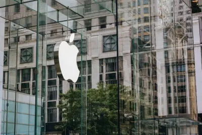 The Apple logo on the glass facade of an Apple Store