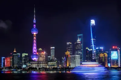 A night skyline of a major Asian city lit up beside its river, illustrating the coronavirus's impact on the economy