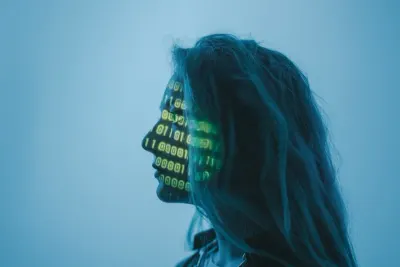 Binary code projected onto a woman's face in profile, symbolising the state of cyberwarfare
