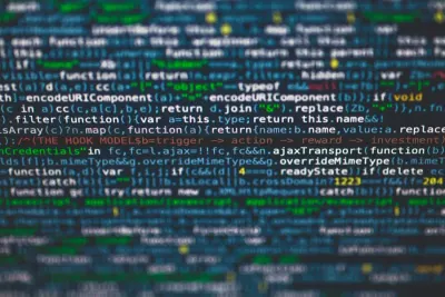 Close-up of blurred blue programming code on a screen, illustrating concerns about dark data