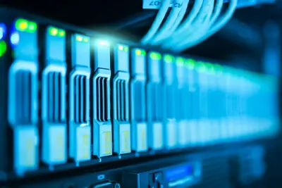 A close-up of illuminated server storage modules and cabling in a data centre, reflecting risks around new technology adoption