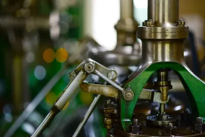 Close-up of polished brass and steel machine components, illustrating the manufacturing workforce