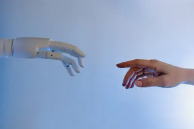 A robotic hand reaching towards a human hand, symbolising AI in the workplace