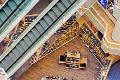 Overhead view of escalators and shelves in a retail store, illustrating customer-centric business models