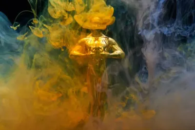 Gold award statuette wreathed in colourful smoke, for the Corporate INTL Global Awards 2023