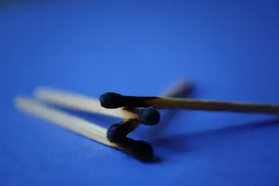 Burnt out matchsticks on a blue background, illustrating employee burn out