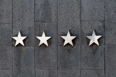 Four metal stars mounted on a dark textured wall, representing online business ratings