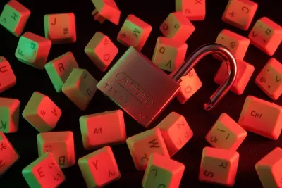 Open padlock lying among scattered keyboard keys under red and green light, illustrating high-risk vulnerabilities