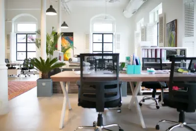 A bright open plan office with an empty potted plant workspace, reflecting persistently high job vacancies