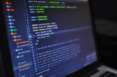 A close-up of programming code on a laptop screen, reflecting strong IT demand in the hiring market