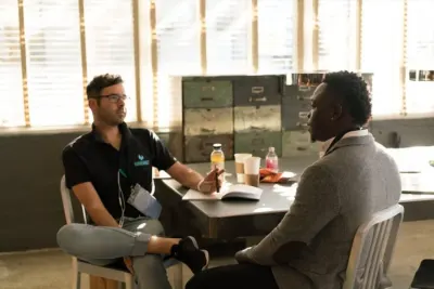 Two men talking across a table in an informal interview setting, illustrating the UK skills crisis
