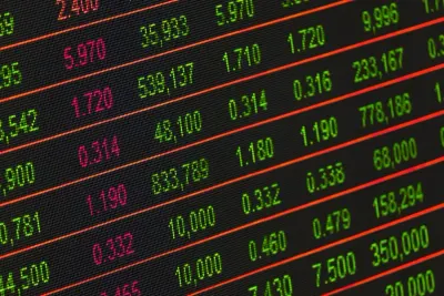 Close-up of a stock market ticker display showing prices and trading volumes, illustrating an impact investment stock exchange