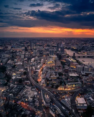 Aerial view of a city skyline at sunset with a river running through it, illustrating the UK economy and intellectual property rights