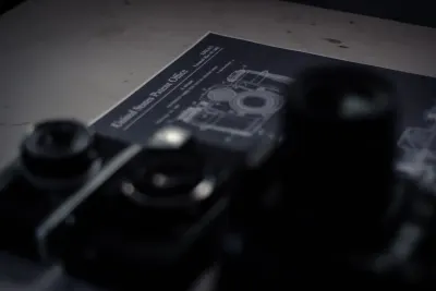 A vintage camera patent document beside old camera equipment, symbolising innovative patents