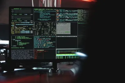 A dark computer screen filled with terminal code and system data, illustrating a ransomware attack