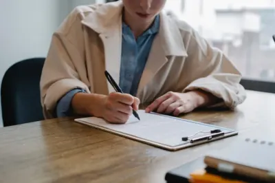 A woman signing a document on a clipboard, illustrating job applicant and vacancy data
