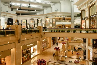 Upmarket shopping mall atrium lined with luxury boutique storefronts, illustrating why consumers still prefer to shop in stores