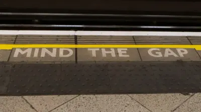 Mind the Gap sign painted on a train platform edge, illustrating a needed skills rethink