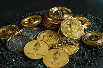 A close-up pile of gold and silver cryptocurrency coins, illustrating losses from crypto scams